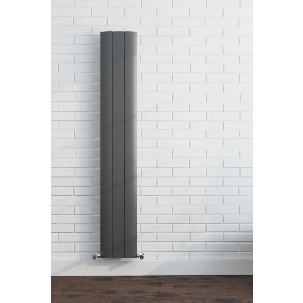 Tall vertical radiator against a white brick wall