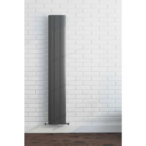 Tall vertical radiator against a white brick wall