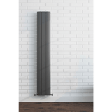 Tall vertical radiator against a white brick wall