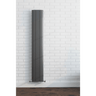 Tall vertical radiator against a white brick wall