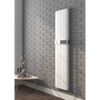 White radiator mounted on a gray brick wall with a small table and decorative items below.