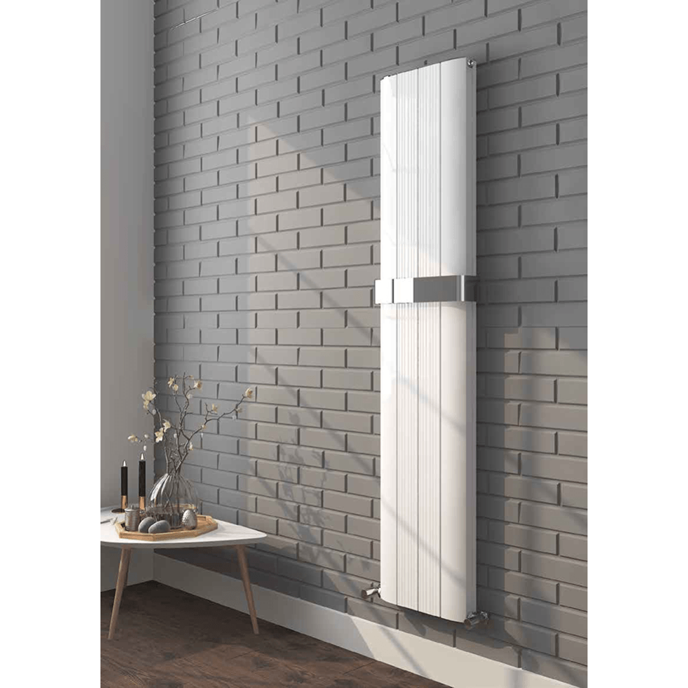 White radiator mounted on a gray brick wall with a small table and decorative items below.