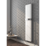 White radiator mounted on a gray brick wall with a small table and decorative items below.