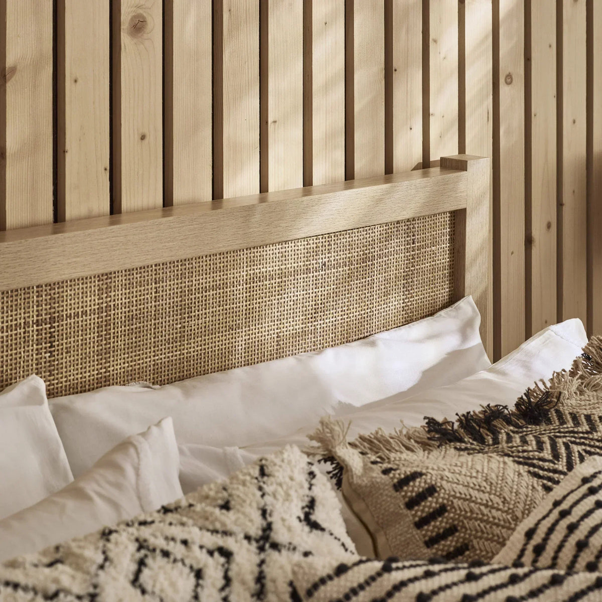Padstow oak rattan double bed headboard detail with pillows and textured cushions