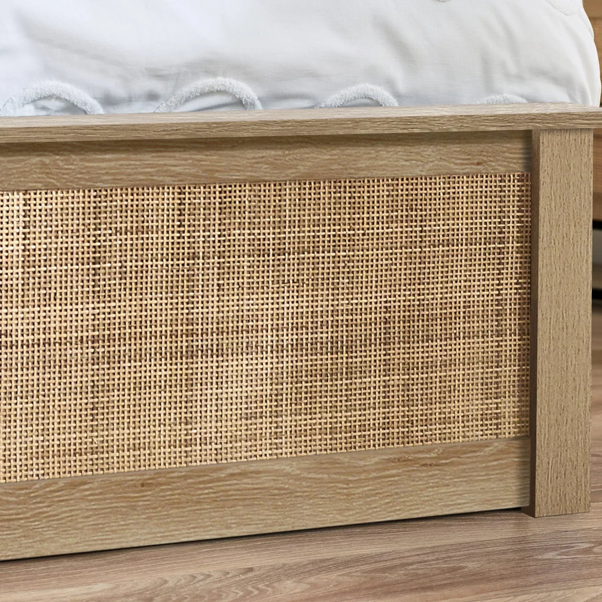 Closeup of oak rattan double ottoman bed footboard showing woven panel and wood grain