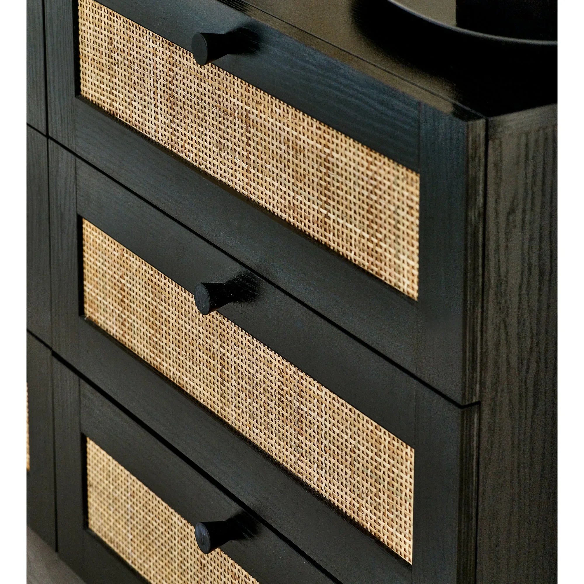 Black 6 drawer chest with rattan panel detail and modern handles, close up angle