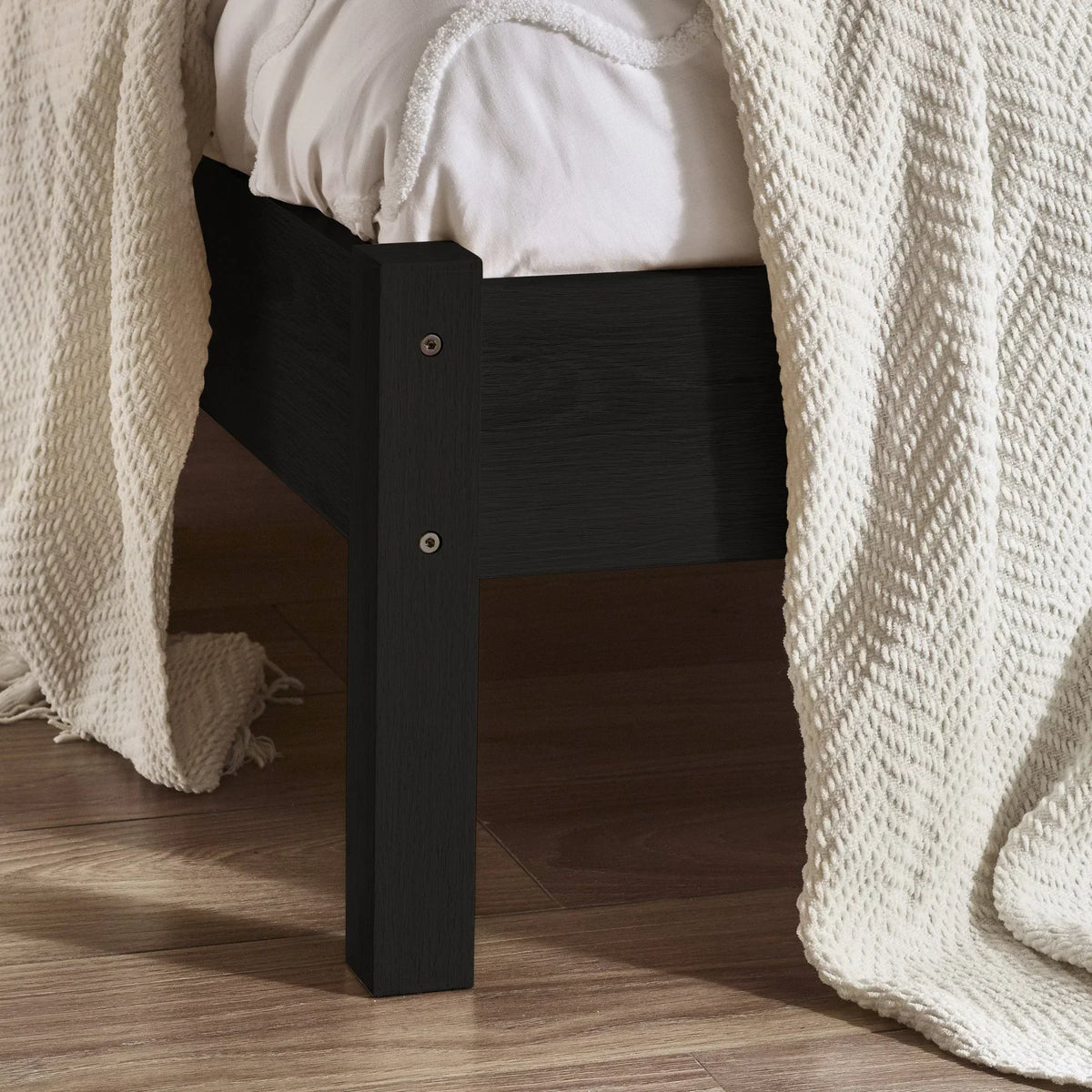 Padstow black rattan double bed frame leg and side detail on wooden floor