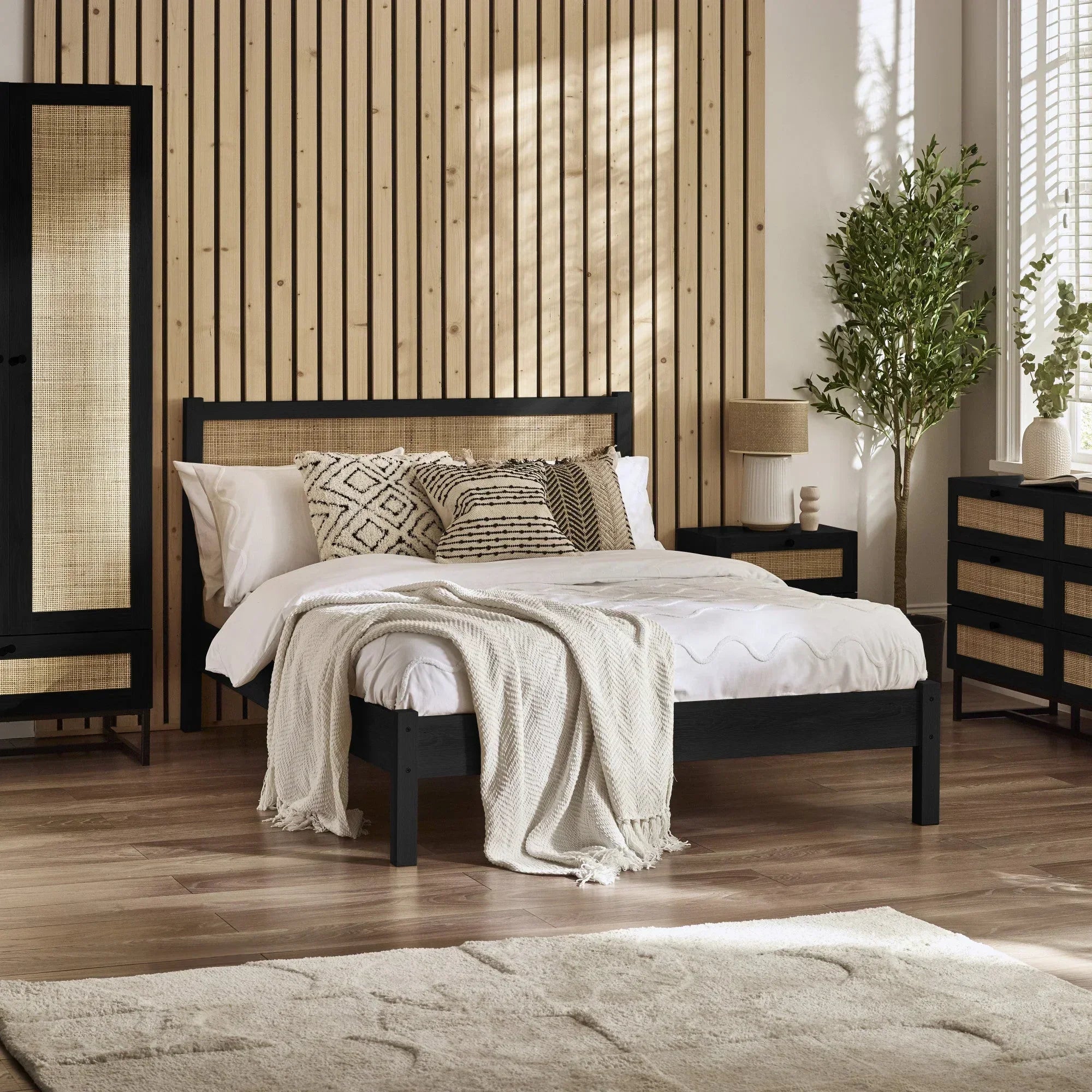 Black rattan double bed with natural woven headboard in modern bedroom setting