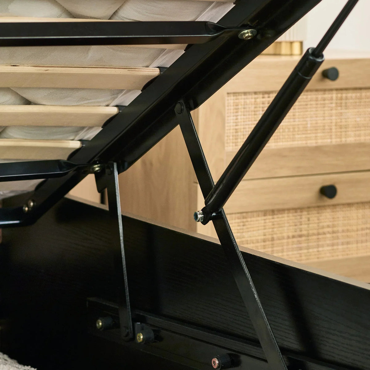 Black rattan ottoman bed gas lift hinge detail with natural wood slats