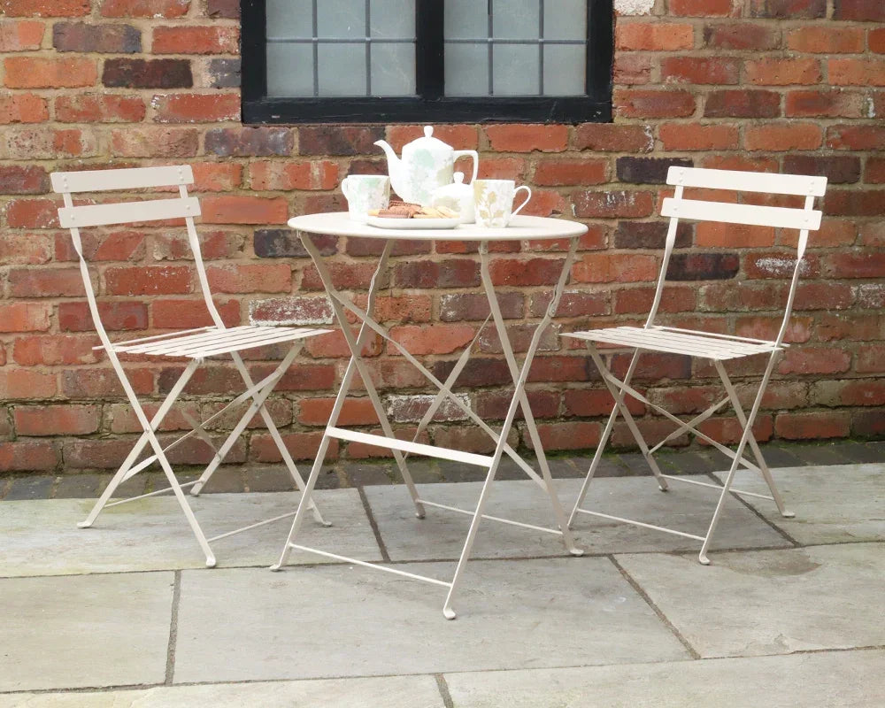 Champagne metal bistro set with two folding chairs and round table on patio