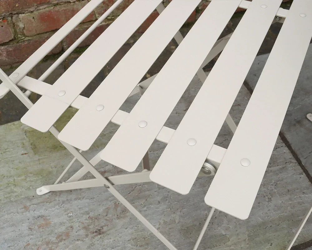 Champagne metal slatted bistro chair close-up on stone patio