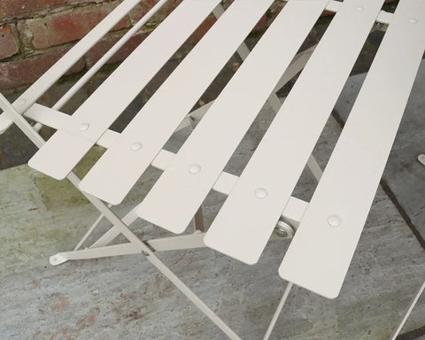 Champagne metal slatted bistro chair close-up on stone patio