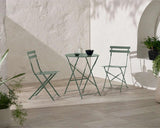 Olive green metal bistro set with folding chairs and round table on tiled patio