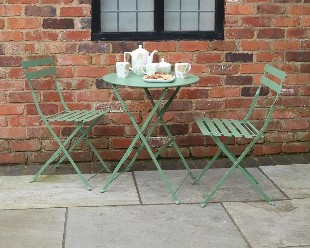 Olive green metal bistro set with two folding chairs and round table set for tea outdoors