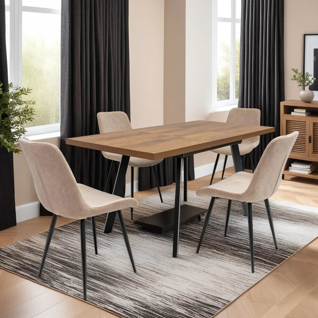 Rectangular wooden dining table with four beige chairs and black metal legs on a modern rug