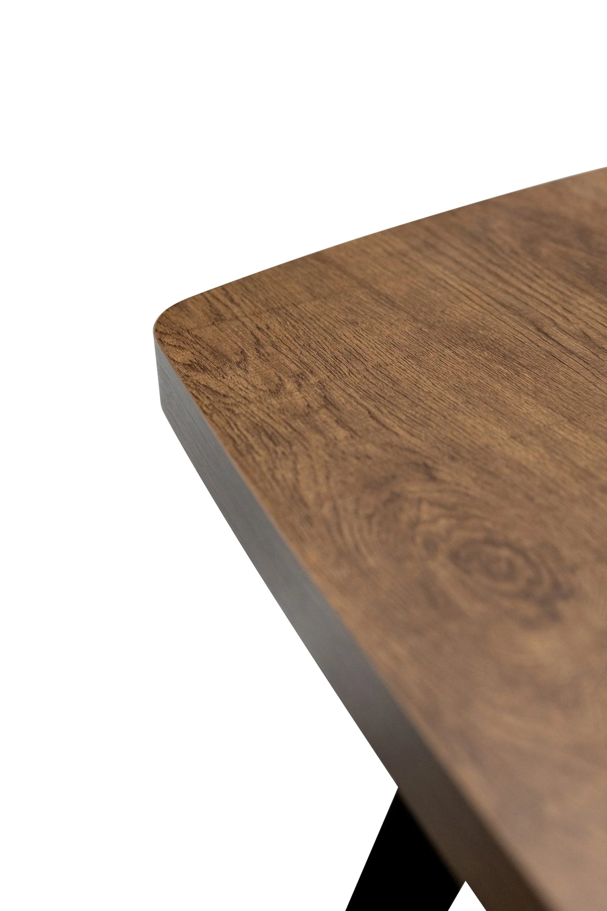 Close-up of wooden dining table corner with visible grain and smooth rounded edge