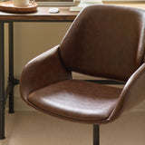 Close-up of brown swivel office chair seat and armrest in home office setting