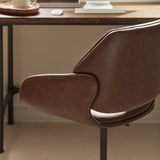 Close-up of brown swivel office chair angled seat and curved armrest in home office