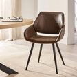Brown upholstered dining chair with tapered black metal legs beside light wood round table in neutral room.