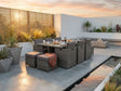 Rattan outdoor dining set with grey cushions and glass table on modern patio at sunset
