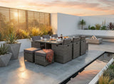 Rattan outdoor dining set with grey cushions and glass table on modern patio at sunset