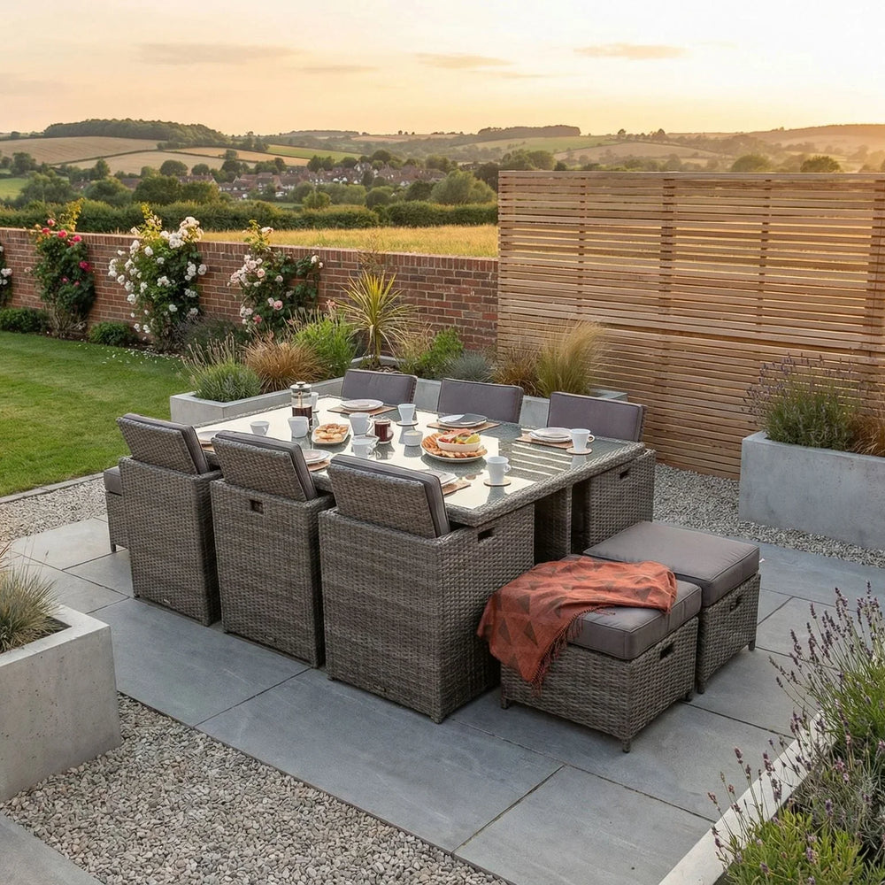Grey rattan outdoor dining set with glass table and seating on modern patio