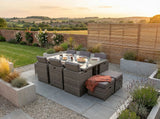 Grey rattan outdoor dining set with glass table and seating on modern patio