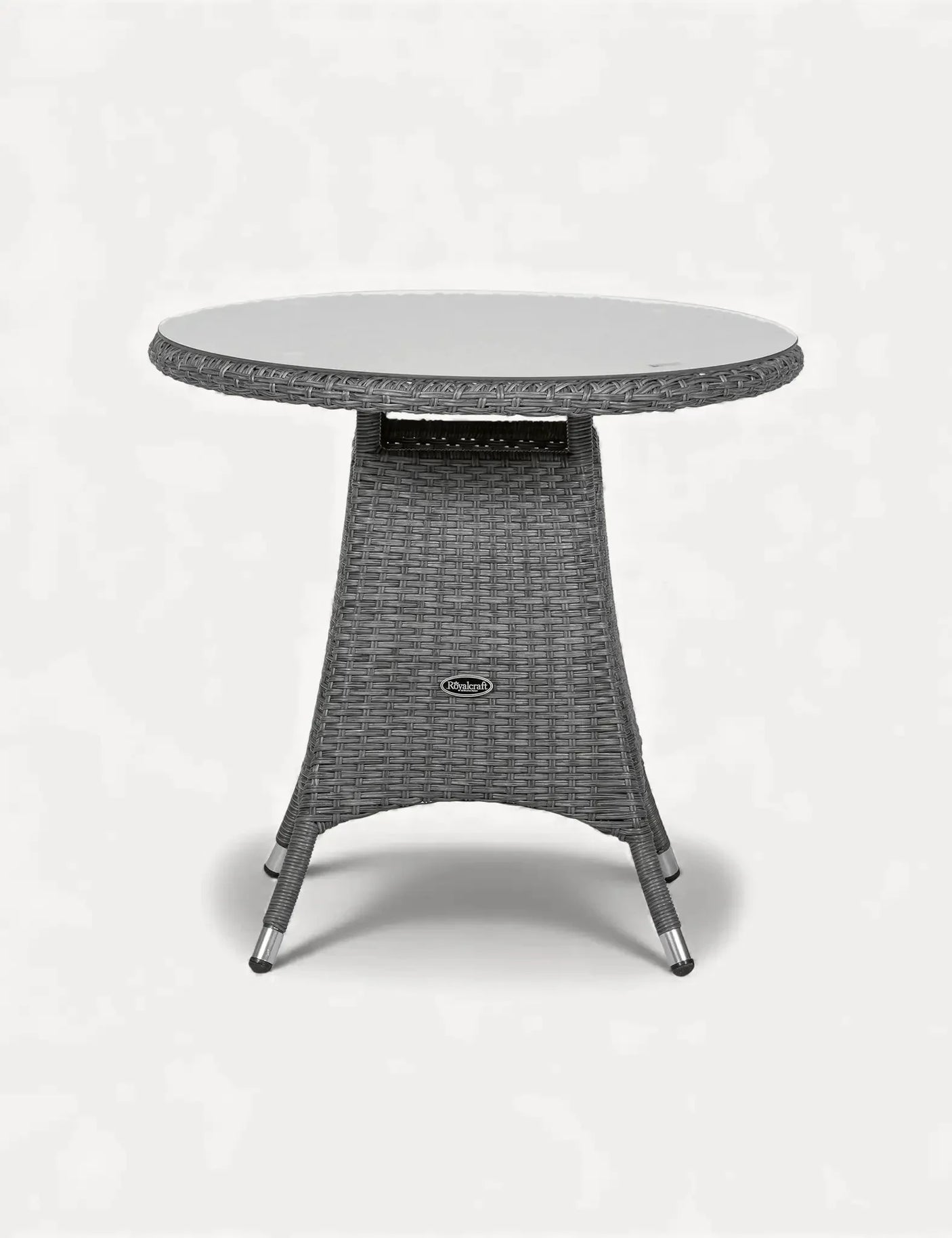 Round rattan garden table with glass top and woven grey base on white background