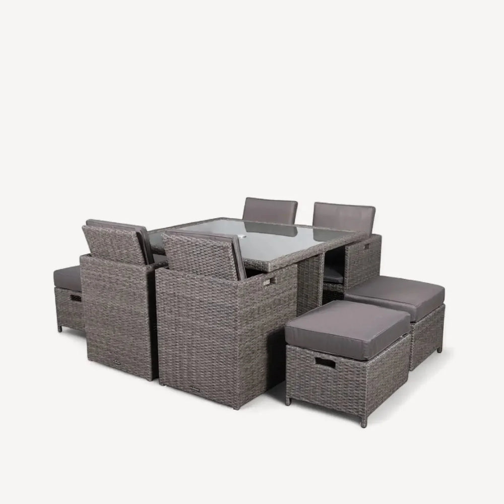 Grey rattan dining set with glass table, cushioned chairs and stools for indoor or outdoor use