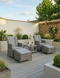Grey rattan reclining garden chairs with cushions and matching footstools on modern patio