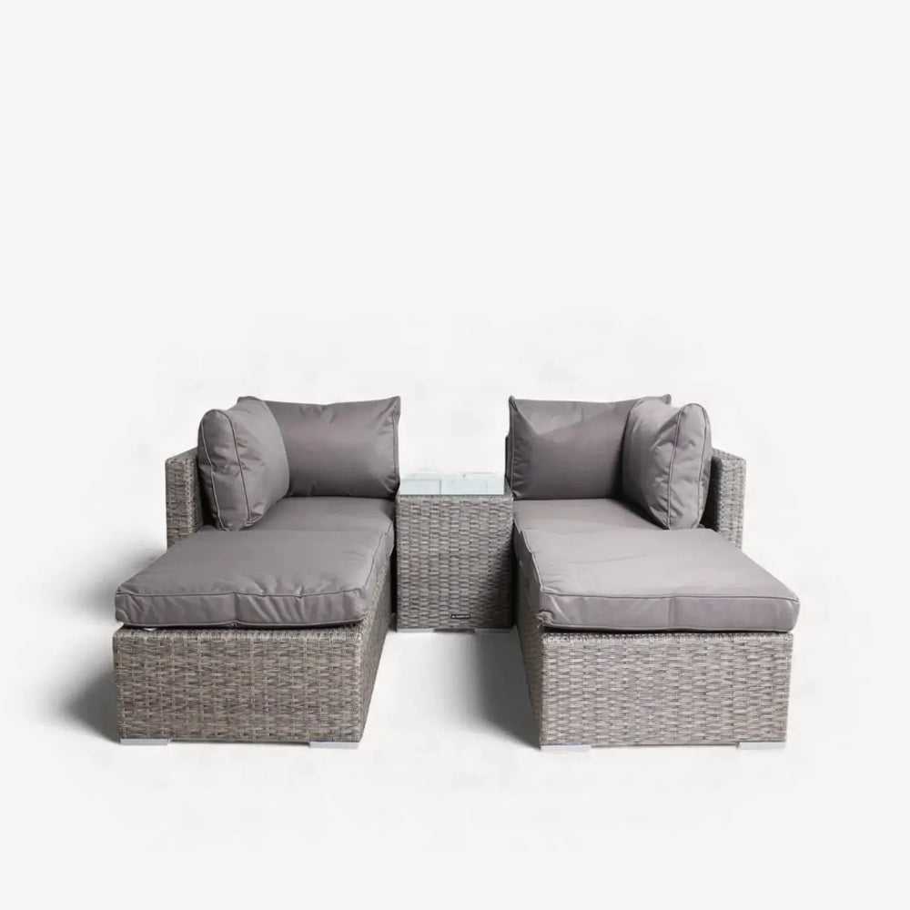 Grey rattan garden sofa set with matching glass-topped side table and plush cushions