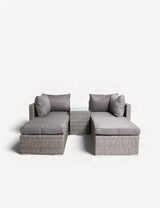 Grey rattan garden sofa set with matching glass-topped side table and plush cushions