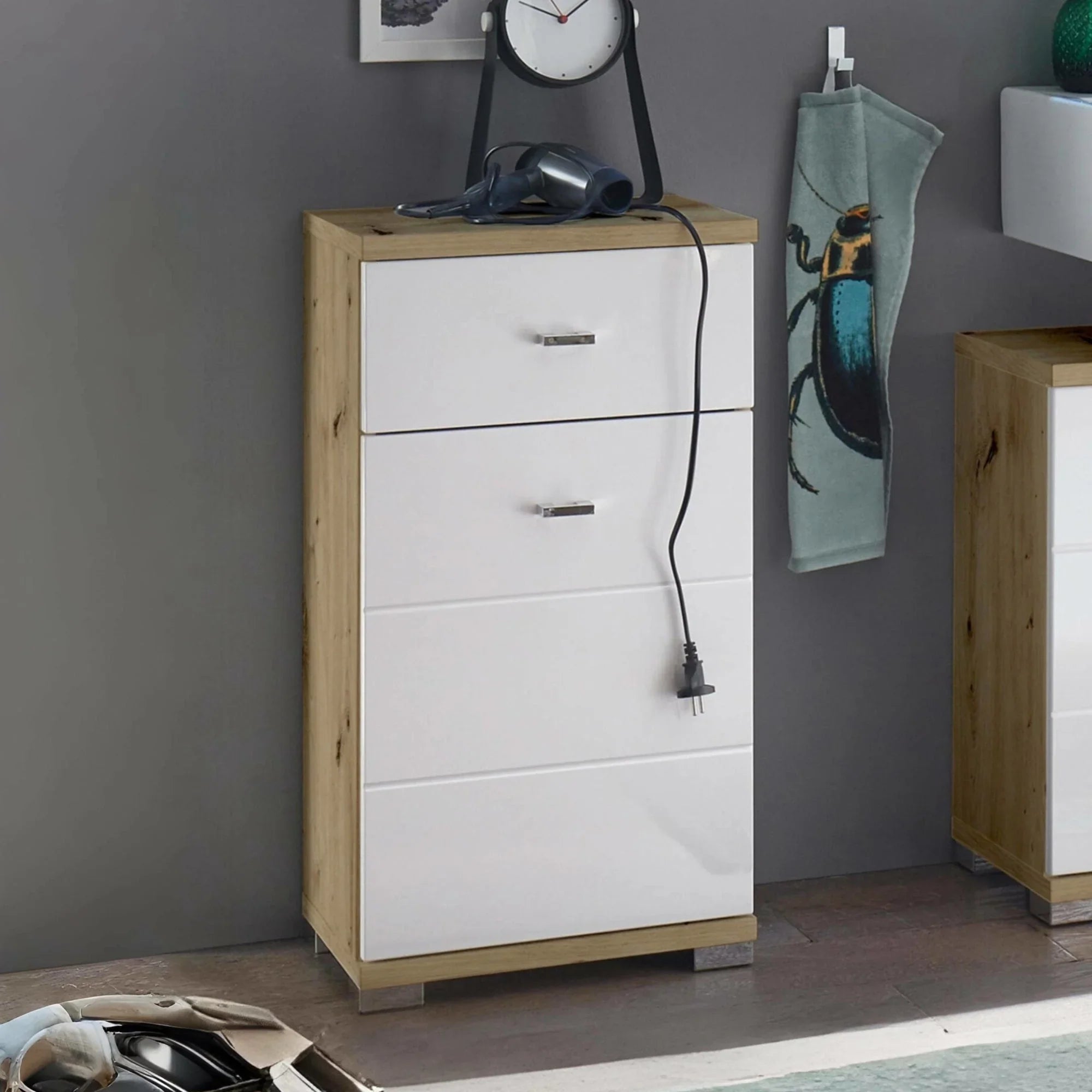 White and oak shoe cabinet with three drawers against grey wall in modern hallway