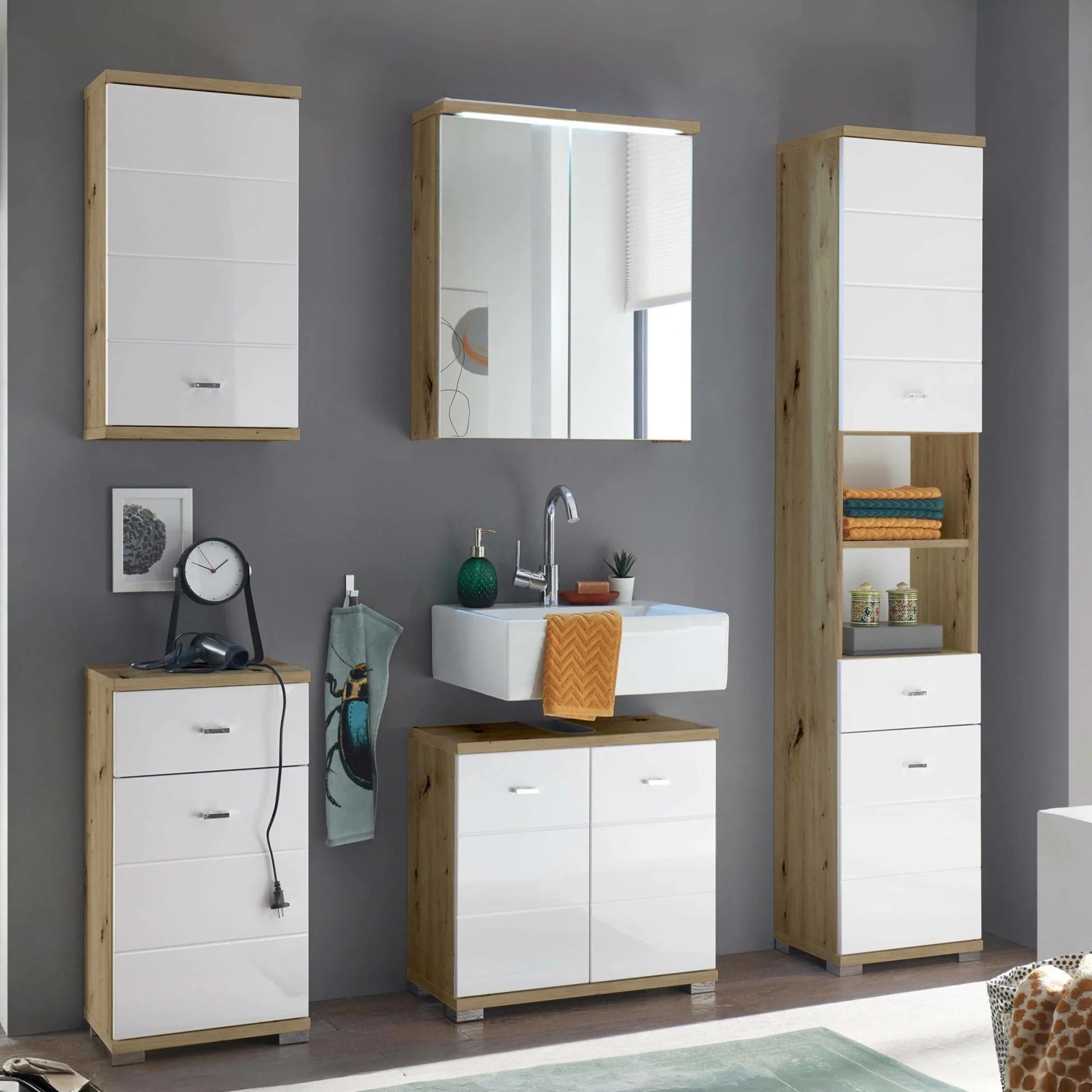 Modern bathroom storage units with white gloss doors and wood effect finish, set against grey wall