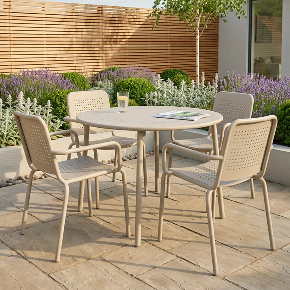 Beige metal outdoor dining set with round table and four chairs on stone patio