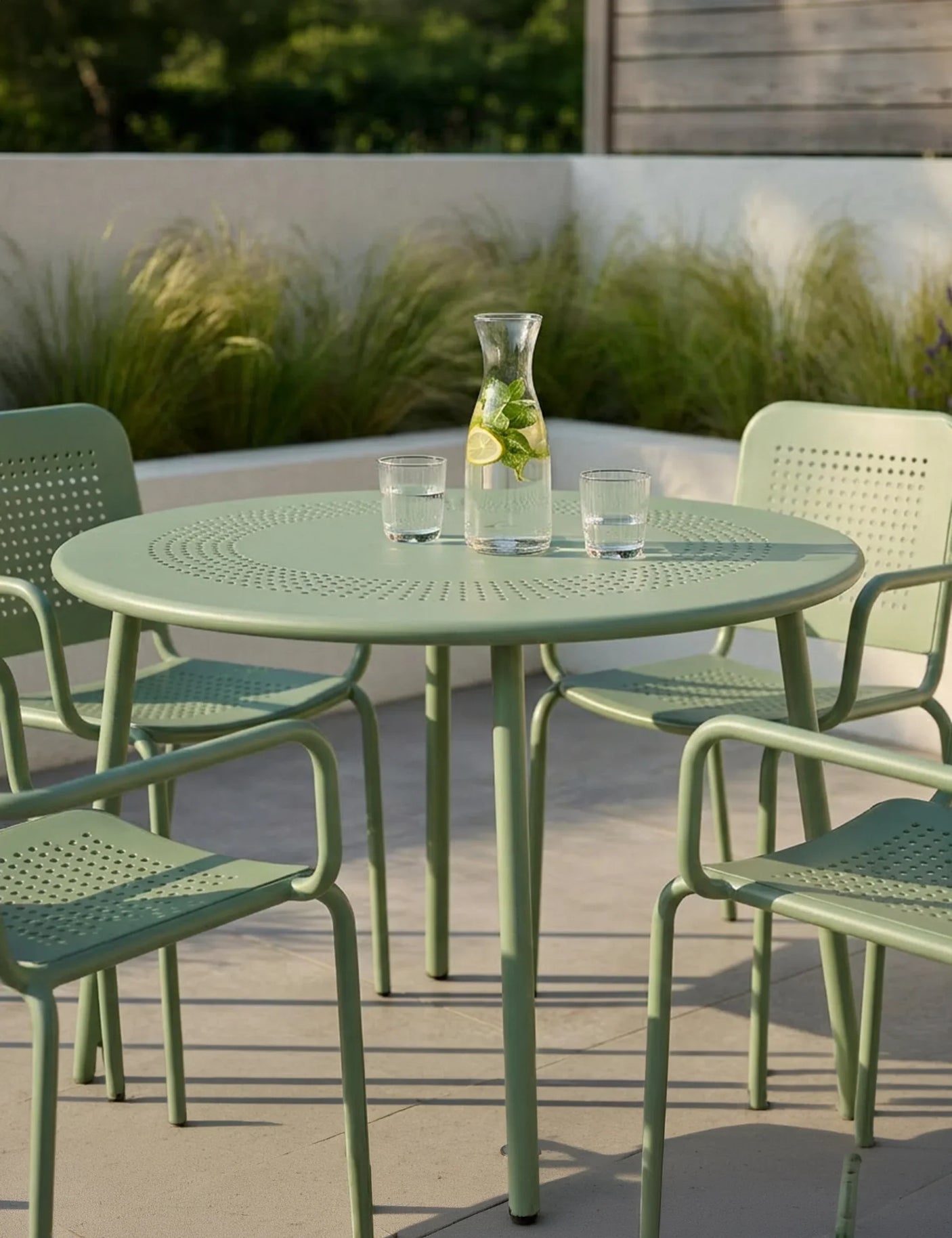 Olive green metal outdoor dining set with matching chairs on patio