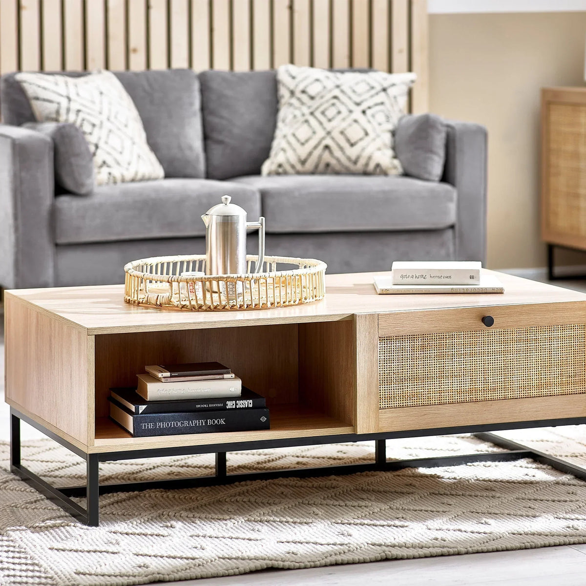 Padstow oak coffee table with rattan door, metal legs and books in modern living room