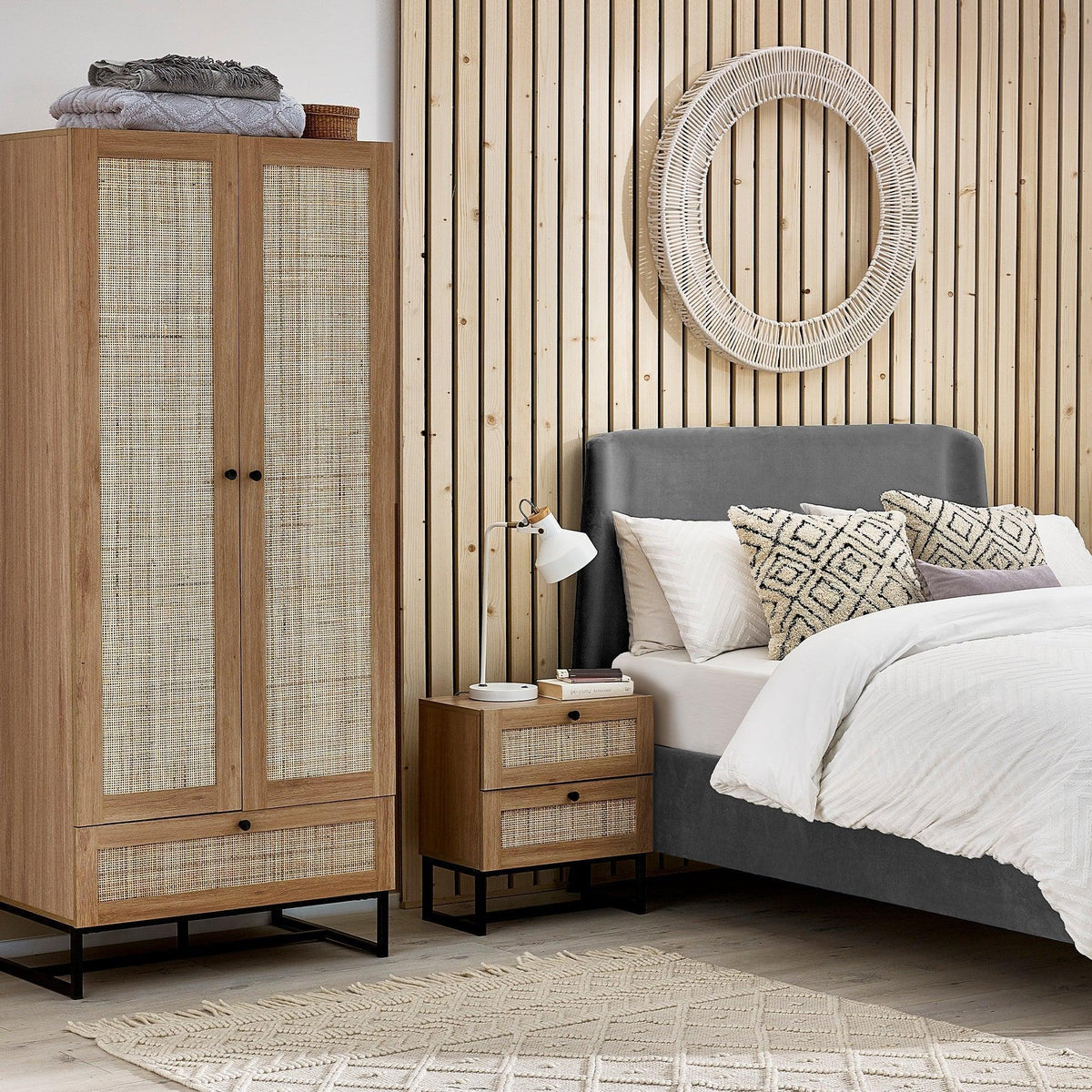 Padstow oak wardrobe with rattan panels next to matching bedside table in modern bedroom