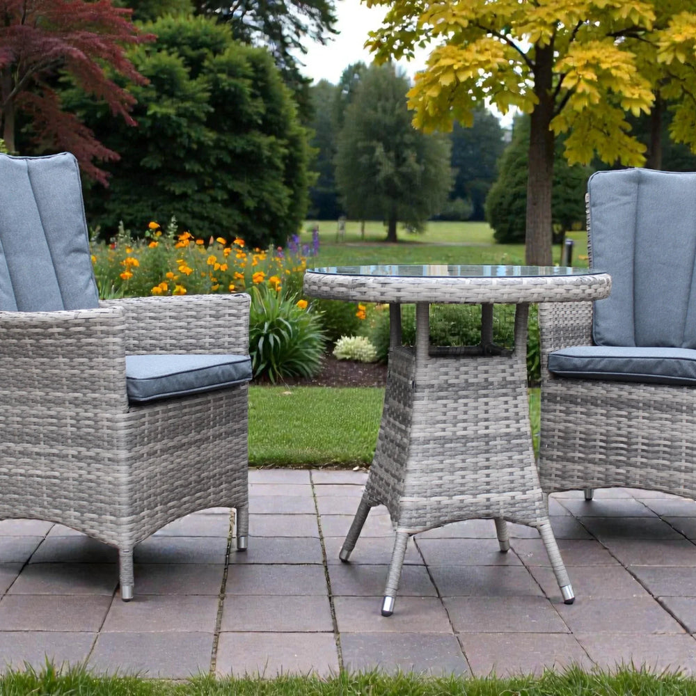 Rattan garden bistro set with two cushioned chairs and round glass top table on patio