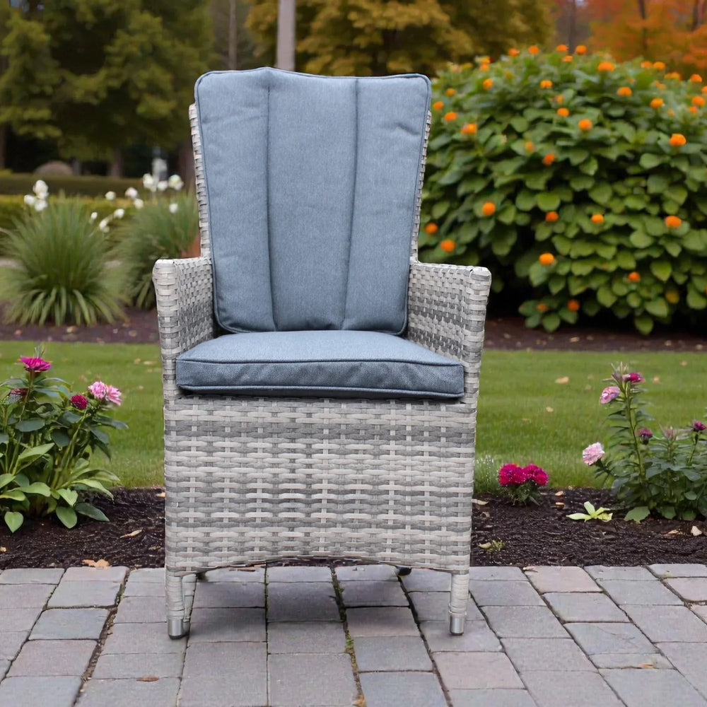 Rattan bistro chair with grey cushions on a patio surrounded by garden flowers