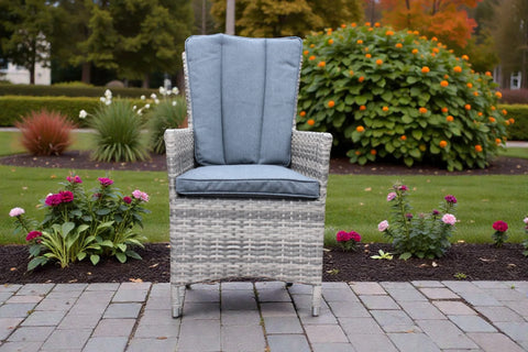 Rattan bistro chair with grey cushions on a patio surrounded by garden flowers