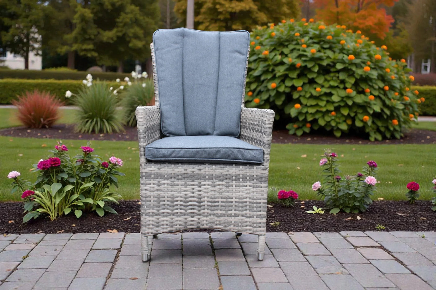 Rattan bistro chair with grey cushions on a patio surrounded by garden flowers