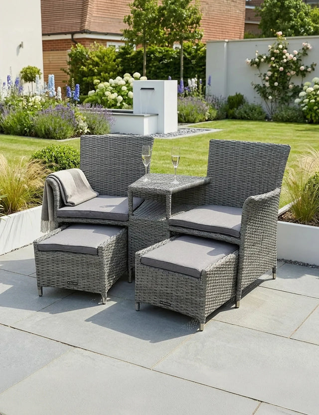 Grey rattan garden furniture set with cushions and glass tabletop on patio