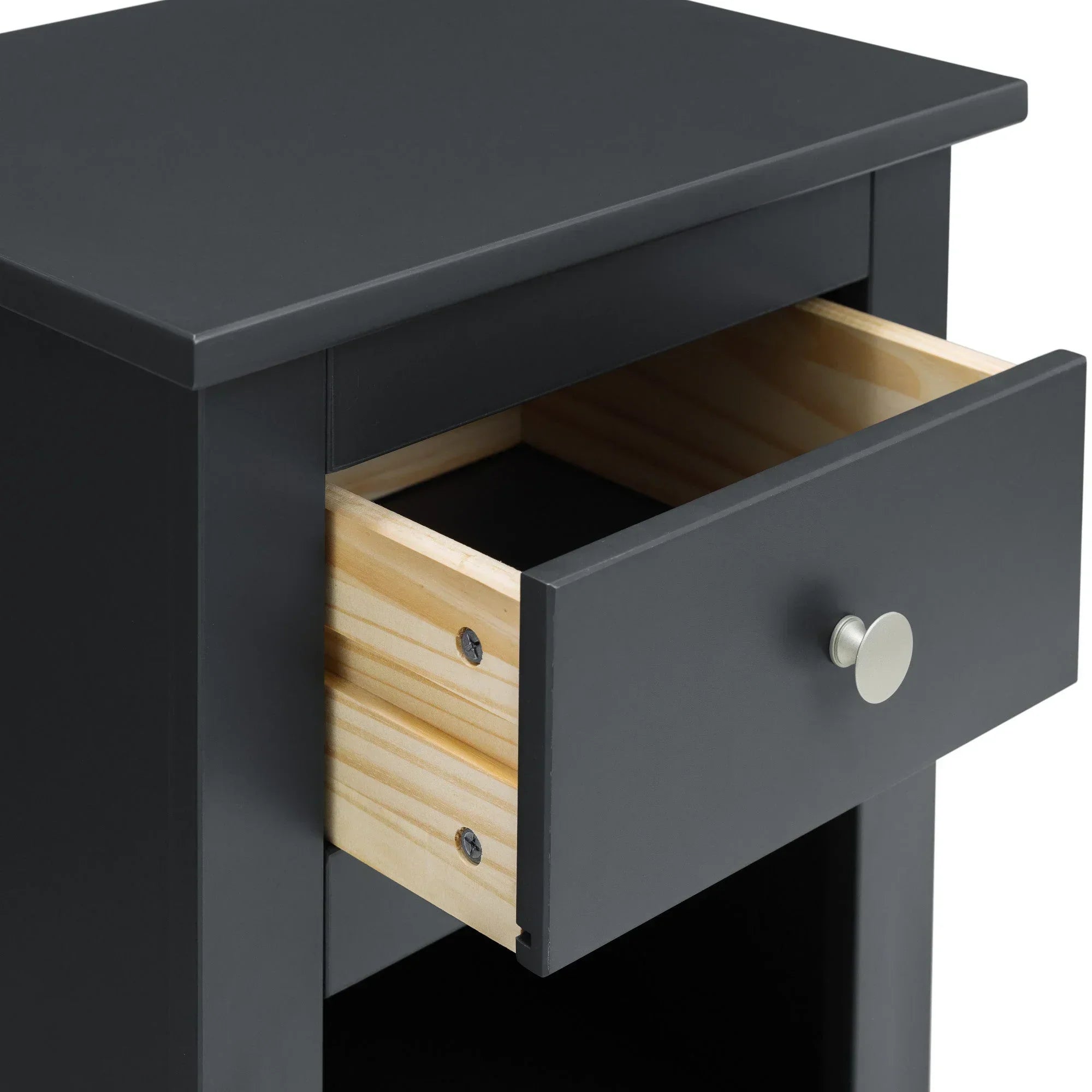 Black bedside table with open wooden drawer and round metal handle, closeup view