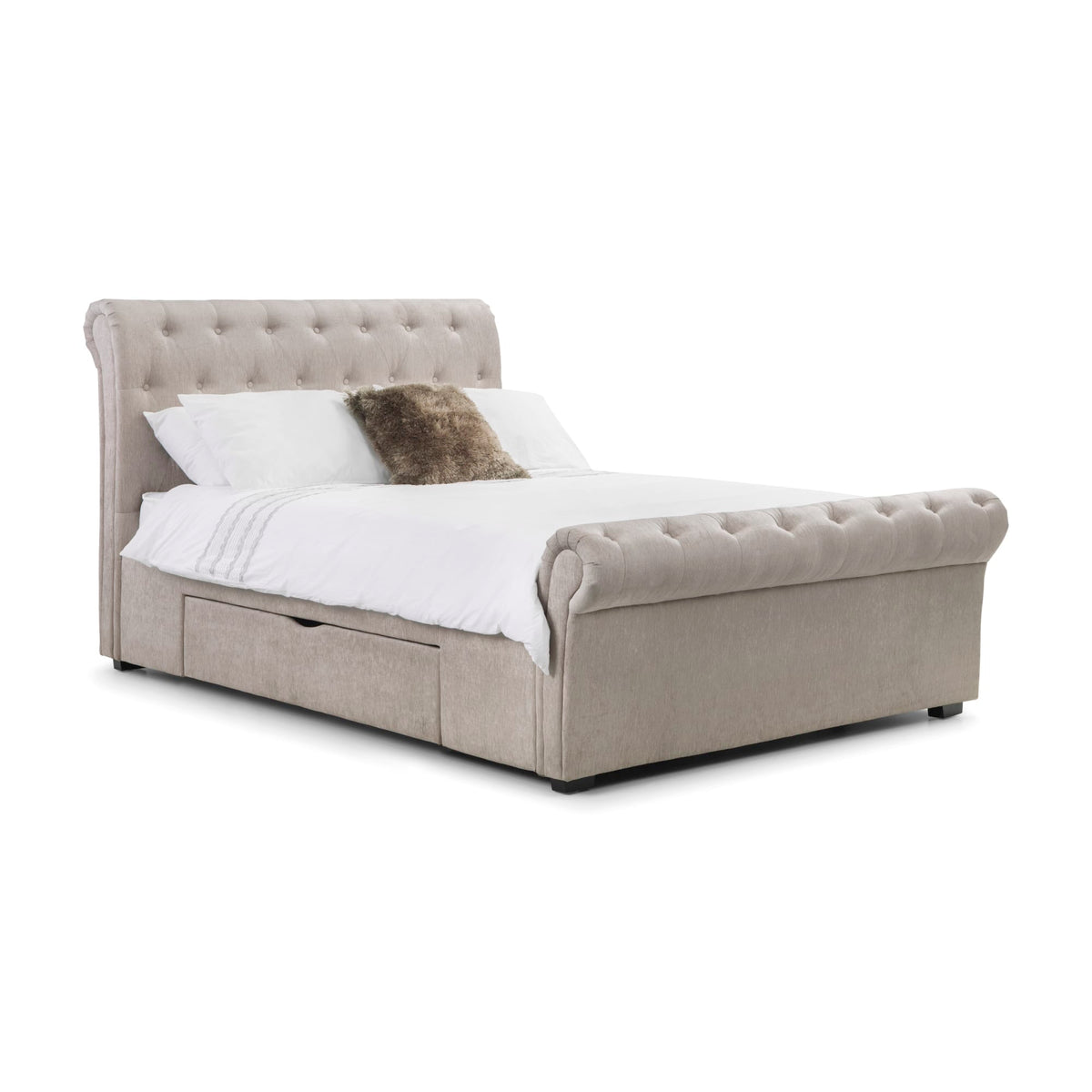 Angled side view of beige fabric button-tufted storage bed with white and brown pillows