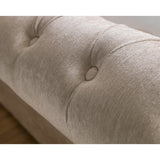 Close-up of beige fabric button tufting on rolled headboard of storage bed