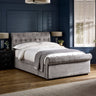 Upholstered grey fabric double bed with tufted headboard and footboard in a dark blue room.