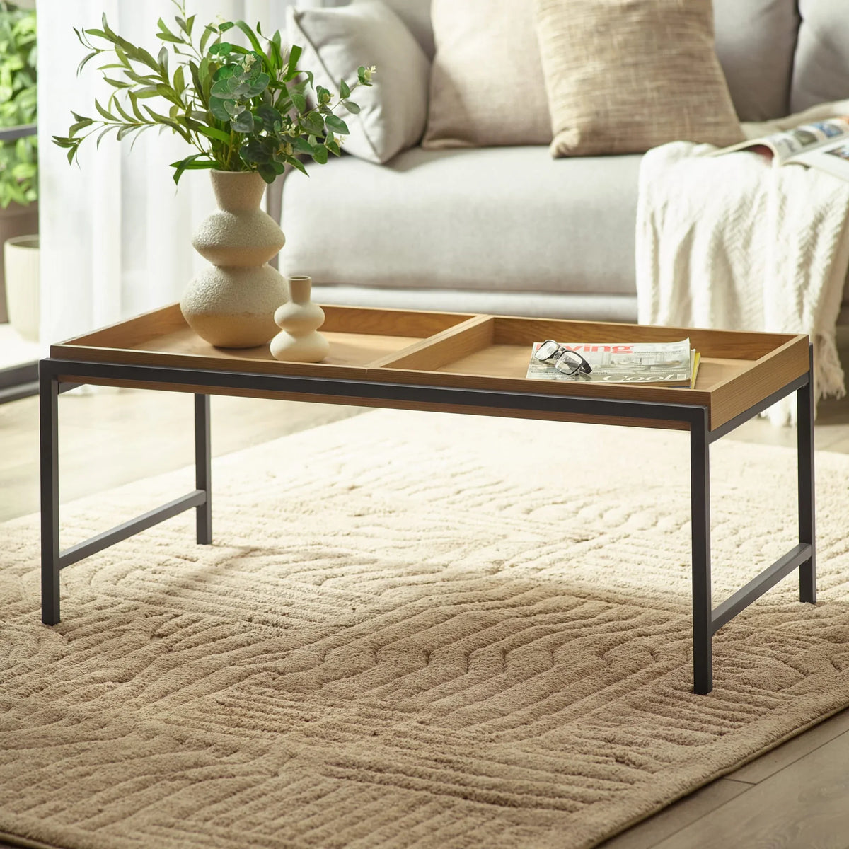 Rectangular wood and metal coffee table with tray top in modern living room setting
