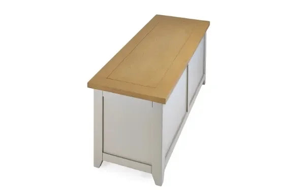 Oak wood storage bench with cream painted base shown from angled side view
