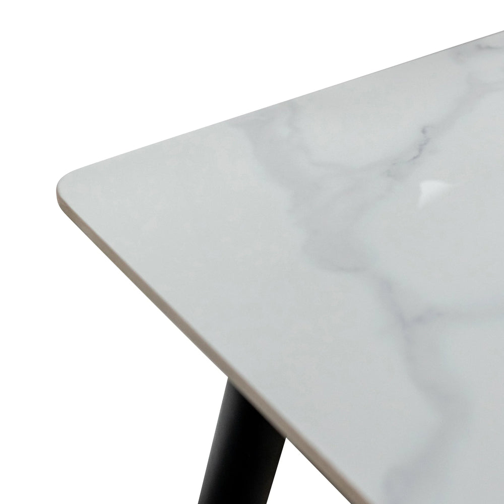 Close-up of white marble dining table top with black angled metal leg